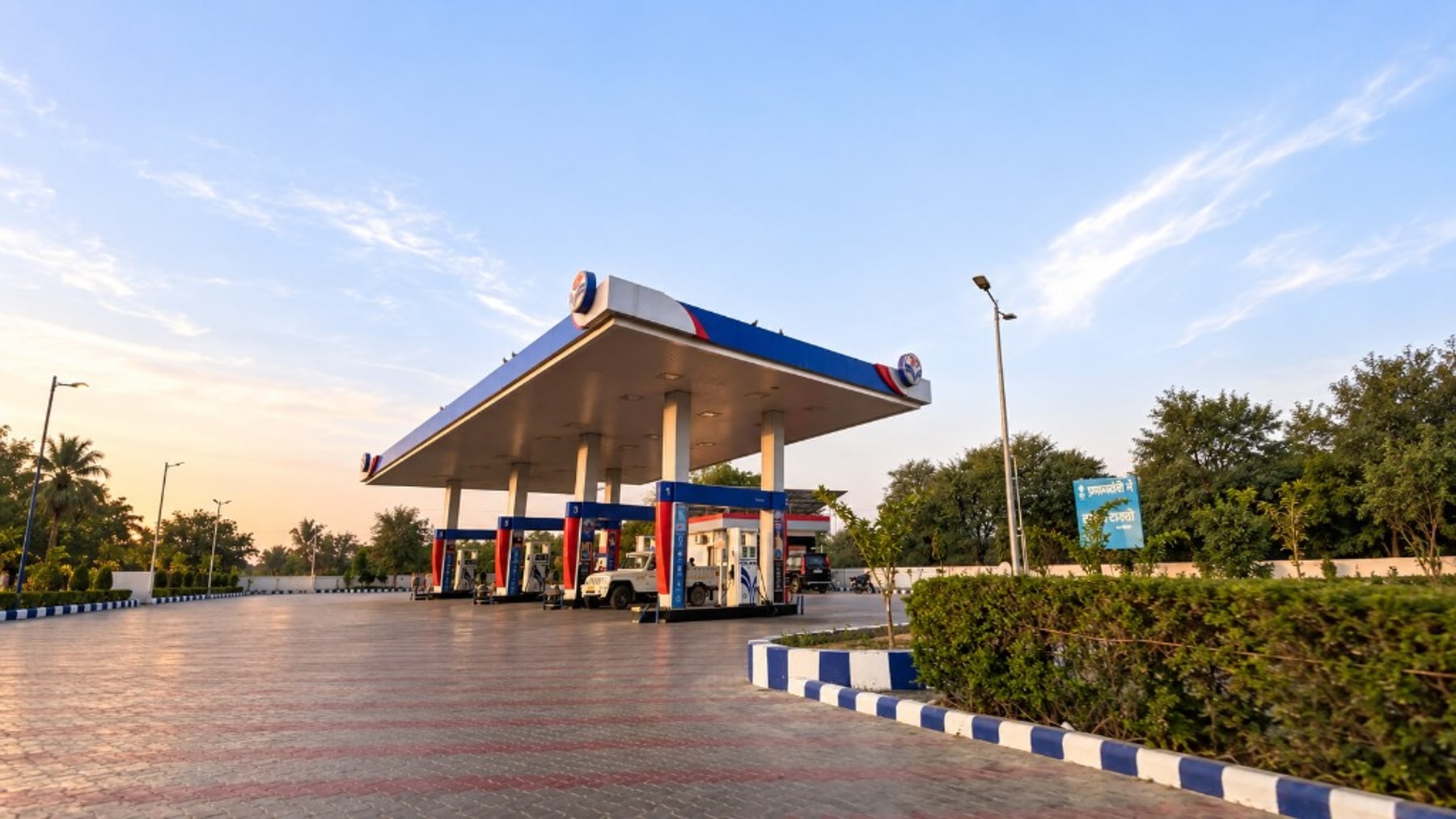 Modern fuel station canopy and forecourt at golden hour
