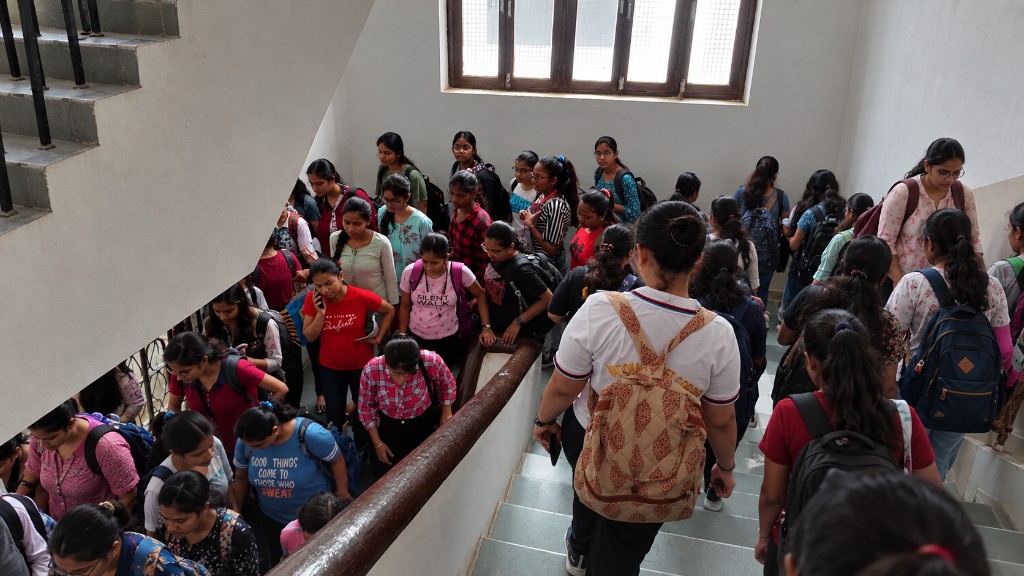 Students moving through a busy college stairwell between classes
