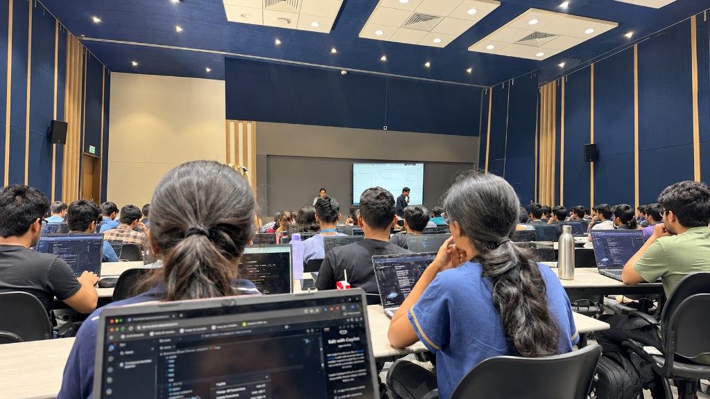 Students attending a technical workshop in a college auditorium with laptops open